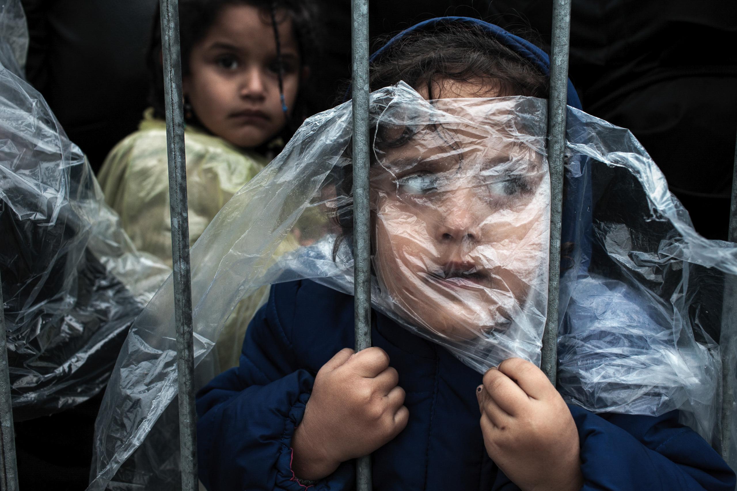 Refugee children covered in rain capes wait in line to be registered. Most refugees who crossed into Serbia continued their journey north, towards countries of the European Union. ©Matic Zorman